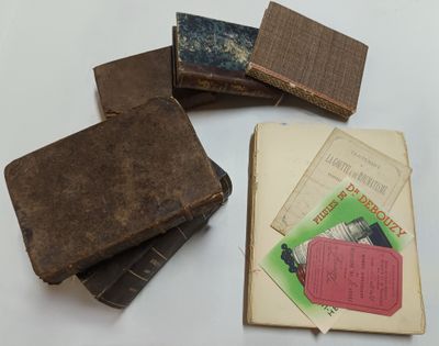 several old books are stacked on top of each other on a table