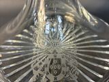 a clear glass vase with a crest on it