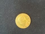 a close up of a gold coin on a black cloth