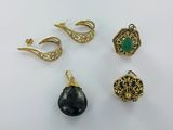 un ensemble de quatre bijoux dorés et noirs