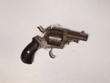 a close up of a revolver on a white surface with a black handle
