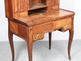 un petit bureau en bois surmonté d'une étagère à livres