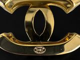 a close up of a gold chanel logo on a black background