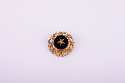 a gold and black broochle with a star on it