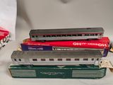 trois trains miniatures assis l'un à côté de l'autre sur une table