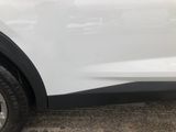 a close up of a white car parked on the side of the road