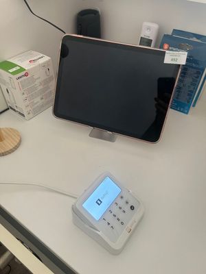 a desk with a monitor, phone, and other items on it