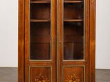 une vieille armoire en bois à deux portes, dont l'une est vitrée