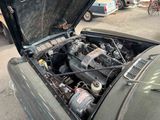 an old car with its hood open on the street