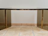 an image of a glass and brass console table