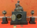 une statue de femme assise au sommet d'une horloge