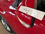 a red car with a measuring tape attached to the side of it