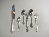 a lot of silverware on a table with a knife and fork