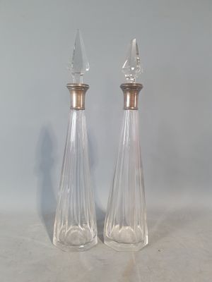 deux bouteilles en verre transparent avec des bouchons argentés posées sur une table