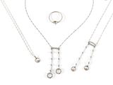 trois colliers en argent et une bague sur fond blanc