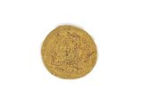 an old gold coin on a white surface with a white background