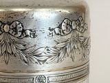 a glass jar with a silver lid sitting on a table