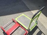 a red and green hand truck sitting on the ground