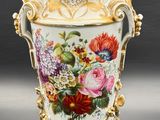 a vase with flowers painted on it sitting on a table