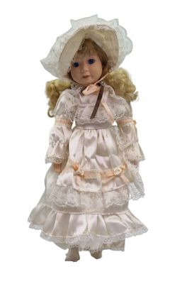 an image of a doll with a white dress and a hat