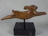 a bronze sculpture of a leaping rabbit on a black marble base