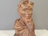 statue of a bust of a man on a wooden base
