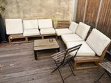un canapé et des chaises sur une terrasse en bois, avec une table