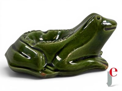 a green ceramic frog sitting on top of a bowl