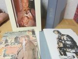 trois livres posés sur une table, sur lesquels figurent des photos de personnes