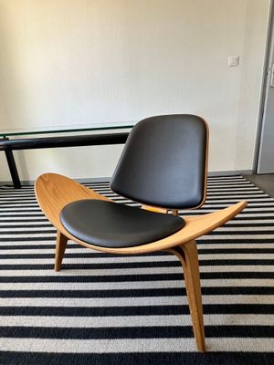 un tapis rayé noir et blanc sur lequel est posée une chaise en bois