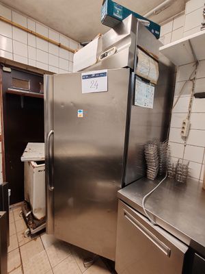 a stainless steel refrigerator in a kitchen with a lot of dishes on the counter
