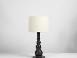 une lampe de table noire surmontée d'un abat-jour blanc