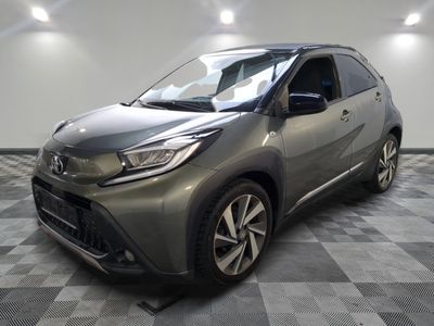 Une Toyota C-HR grise est garée sur un sol à damier