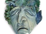 un visage vert sur lequel sont disposées plusieurs feuilles vertes