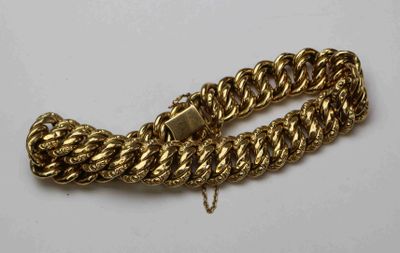 gros plan d'un bracelet en chaîne en or sur une surface blanche