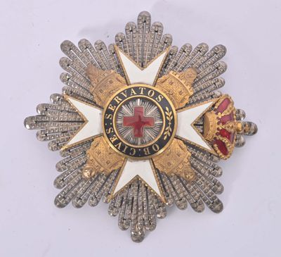 an image of a silver and gold broochle with a red cross on it