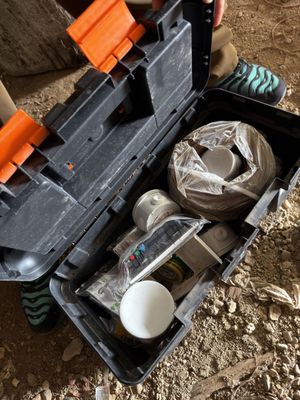 a person holding a tool box with items in it