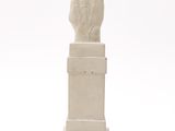 statue of a hand with a finger up on a pedestal