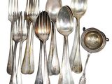 a lot of silver spoons and spoons on the table