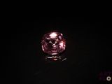 a close up of a pink diamond on a black surface