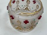 a glass bowl with a gold rim and red flowers