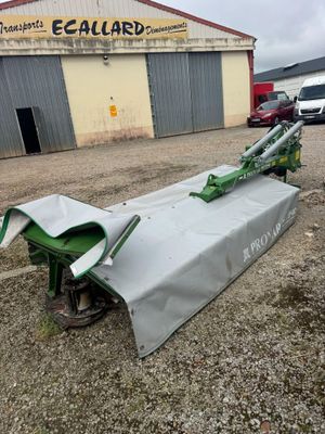 a tractor with a cover on it is parked in front of a building