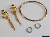 un gros plan sur un bracelet, une bague et une boucle d'oreille posés sur une table