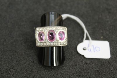an image of a silver ring with pink stones and a price tag
