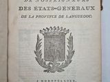 un livre ouvert sur lequel figure un blason