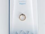 a close up of a ring in a package on a white background