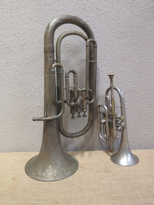 a silver trumpet and a silver trumpet sitting on a table