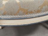 a close up of a chair with a blue and gold upholstered