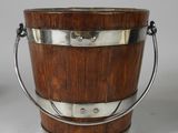 a wooden bucket with a metal handle on a table