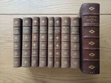 several old books are lined up on a wooden table